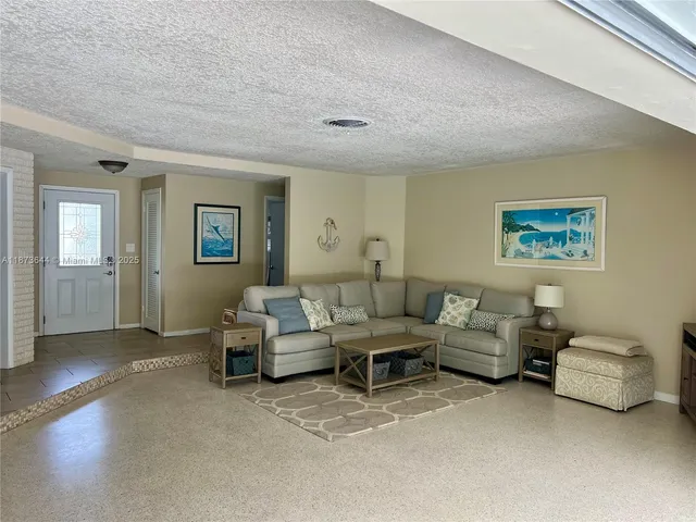 a living room with furniture and painting on the wall