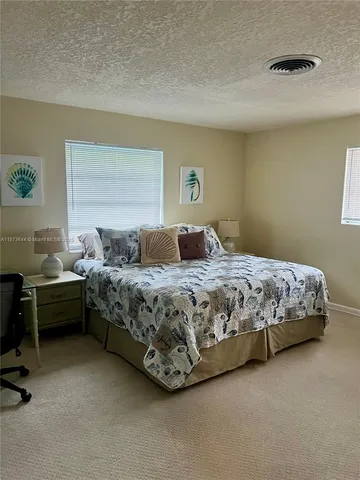 a bedroom with a bed chair and a desk