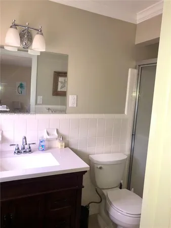 a bathroom with a sink a toilet a mirror and shower curtain