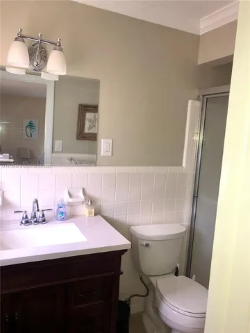 a bathroom with a sink a toilet a mirror and shower curtain