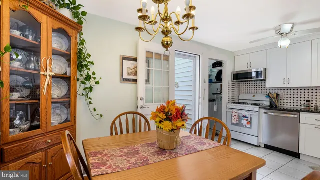 a kitchen with stainless steel appliances granite countertop a sink dishwasher and a stove top oven with a dining table