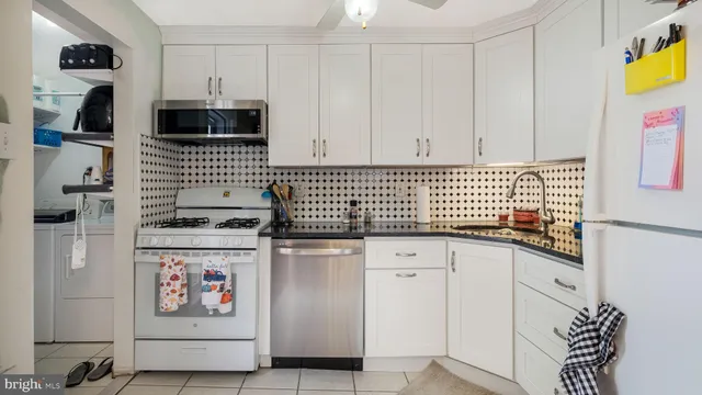 a kitchen with stainless steel appliances a sink a stove a refrigerator and cabinets