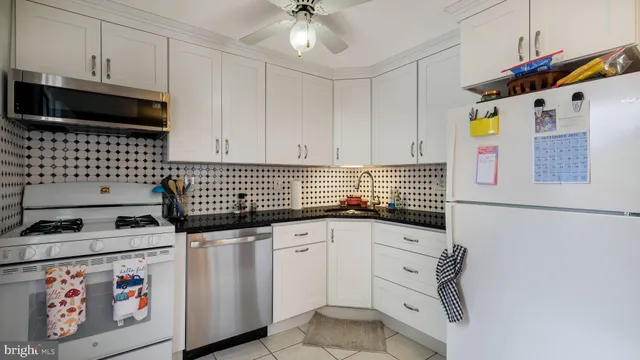 a kitchen with granite countertop a sink a stove and cabinets