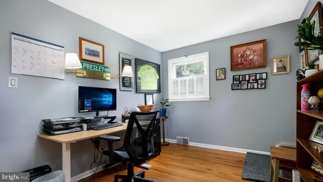 a view of a workspace with furniture and a window
