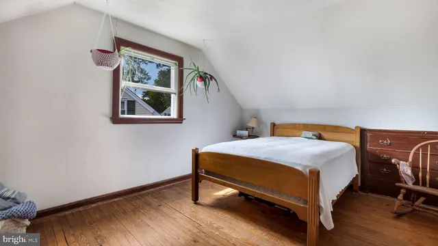 a bedroom with a bed a table and painting on the wall
