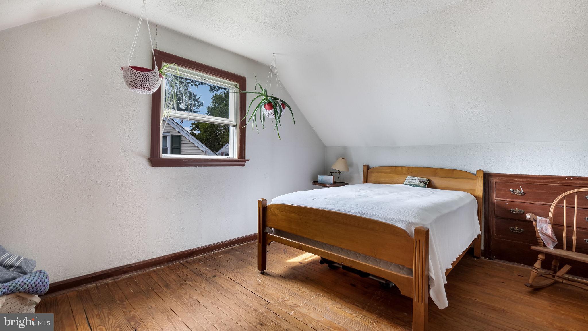 1012 Brook Avenue Secane, PA 19018 - Photo 21 of 28 a bedroom with a bed a table and painting on the wall