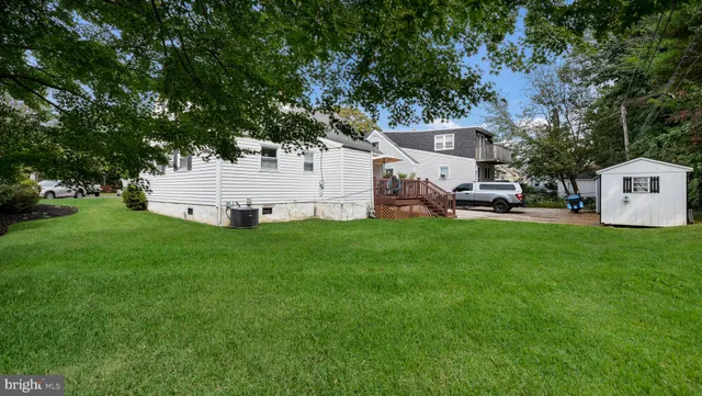 a view of a white house with a yard and sitting area
