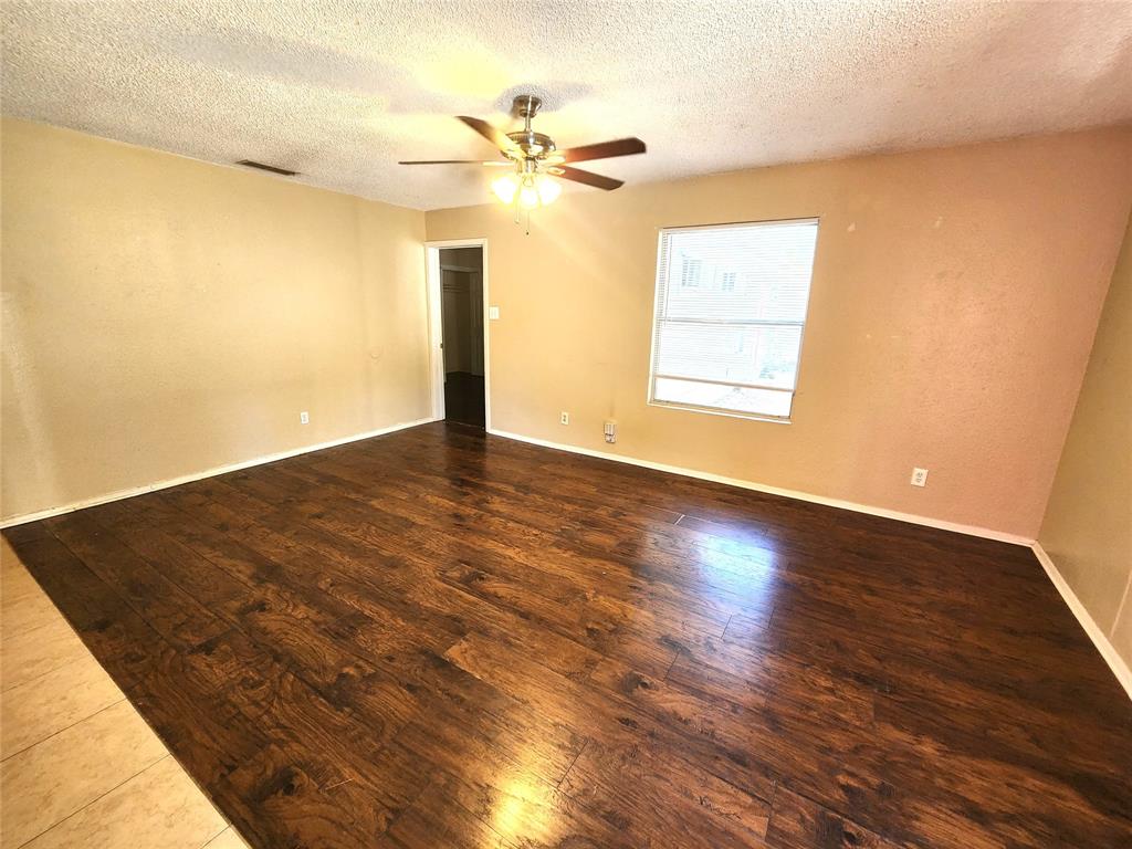 610 Genard Street, Unit A Austin, TX 78751 - Photo 10 of 15 Empty room with a textured ceiling, wood finished floors, and a ceiling fan