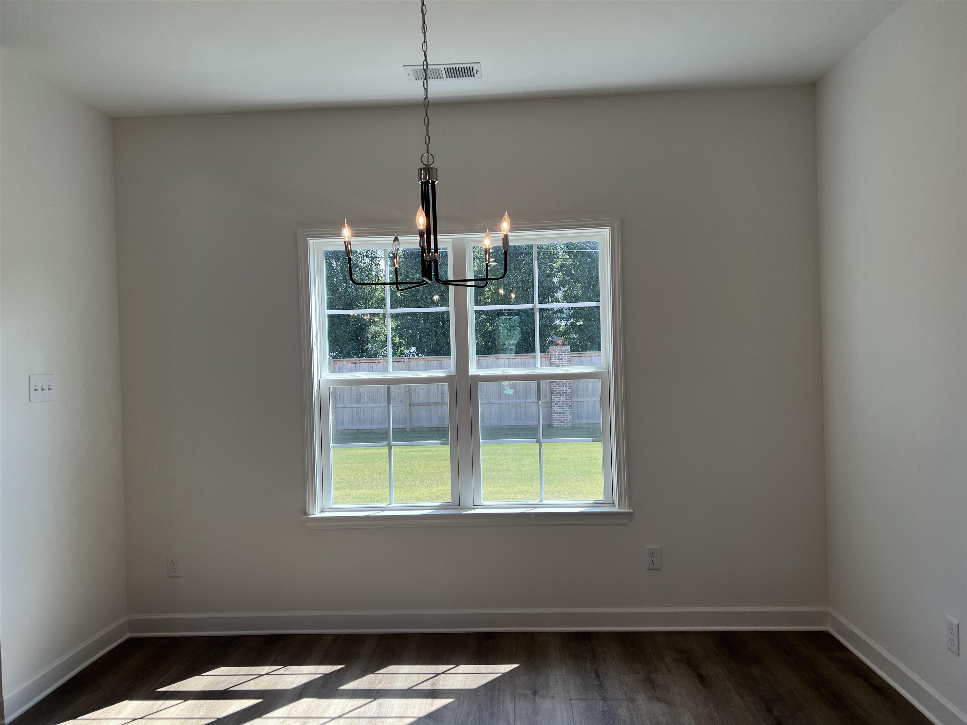 45 Rolling Hill Drive Collierville, TN 38017 - Photo 8 of 24 a view of an empty room with wooden floor and a window