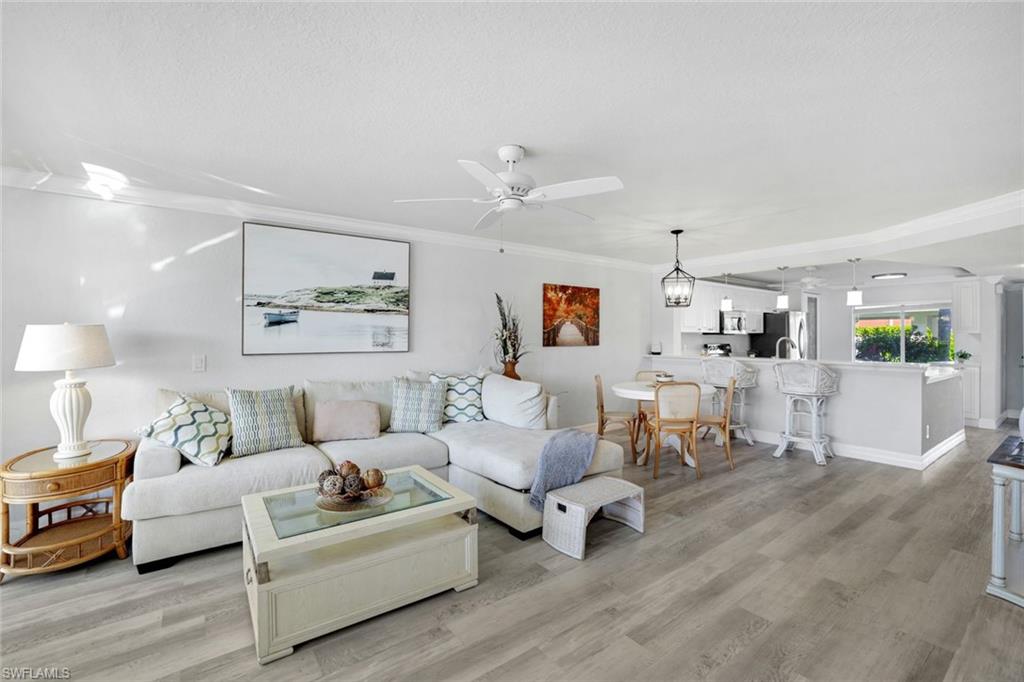 409 Gabriel Circle, Unit 2203 Naples, FL 34104 - Photo 12 of 24 Dining space featuring crown molding, lCoretex vinyl flooring, and light fixture.