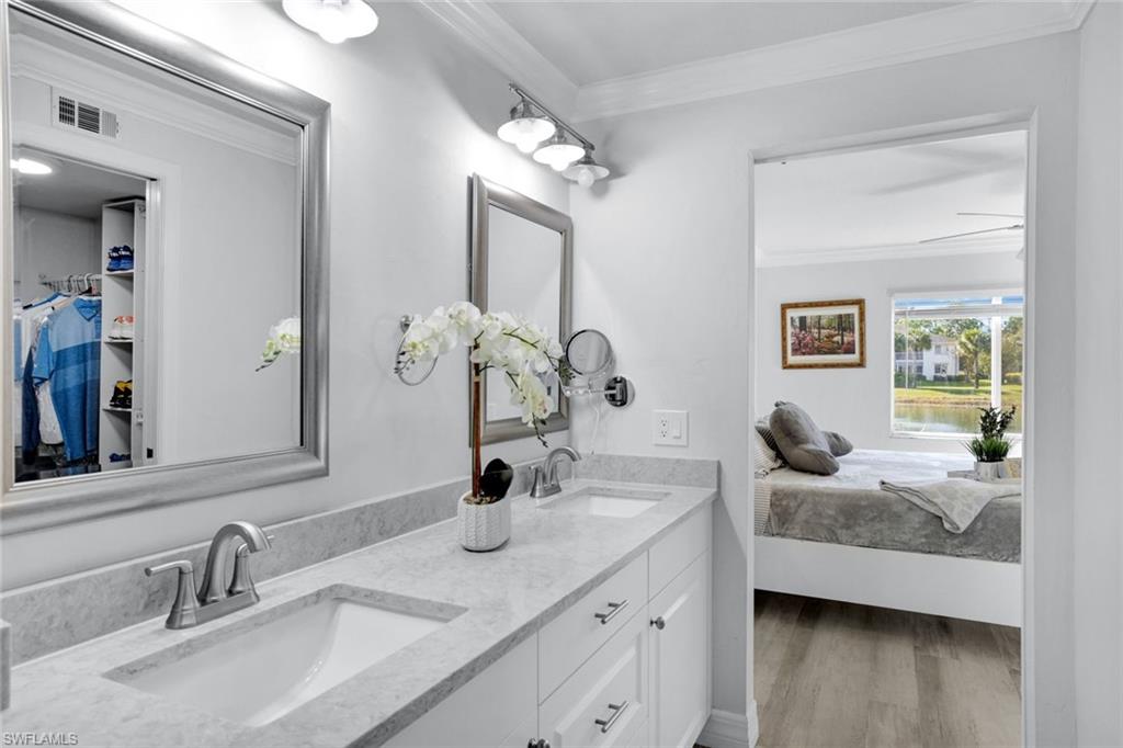 409 Gabriel Circle, Unit 2203 Naples, FL 34104 - Photo 16 of 24 Bathroom with ceiling fan, vanity, Coretex vinyl flooring, and crown molding