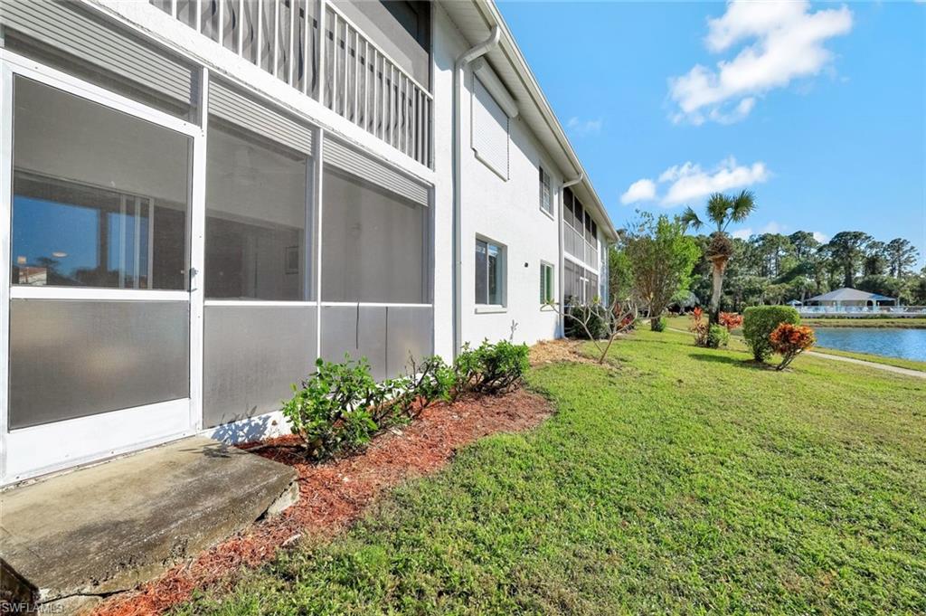 409 Gabriel Circle, Unit 2203 Naples, FL 34104 - Photo 19 of 24 View of property exterior with a water view and a yard