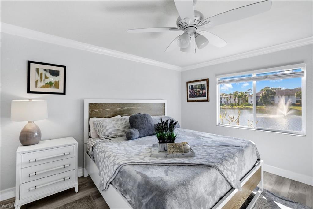 409 Gabriel Circle, Unit 2203 Naples, FL 34104 - Photo 3 of 24 Primary bedroom featuring crown molding and water view with a water feature