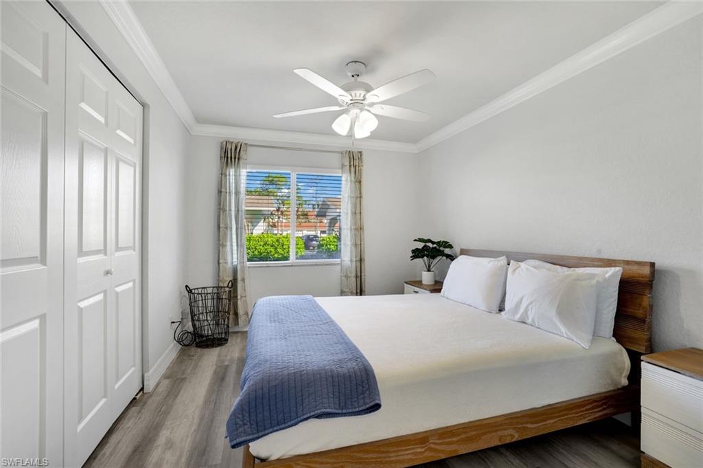 409 Gabriel Circle, Unit 2203 Naples, FL 34104 - Photo 5 of 24 Bedroom #2 featuring Cortex vinyl flooring, a closet, ceiling fan, and ornamental molding