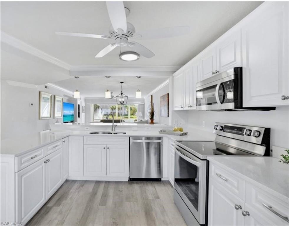 409 Gabriel Circle, Unit 2203 Naples, FL 34104 - Photo 8 of 24 Kitchen with kitchen peninsula, sink, white cabinets, and stainless steel appliances