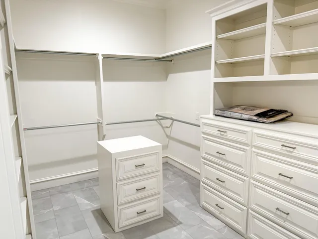 a view of an empty room with closet and windows