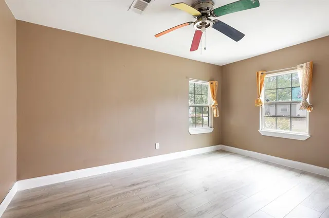 wooden floor in an empty room with a window