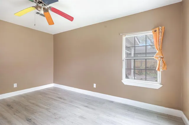 an empty room with windows and wooden floor