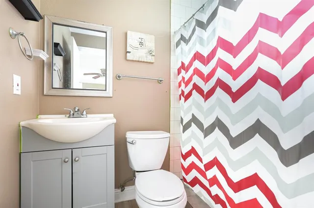 a bathroom with a sink and mirror with toilet