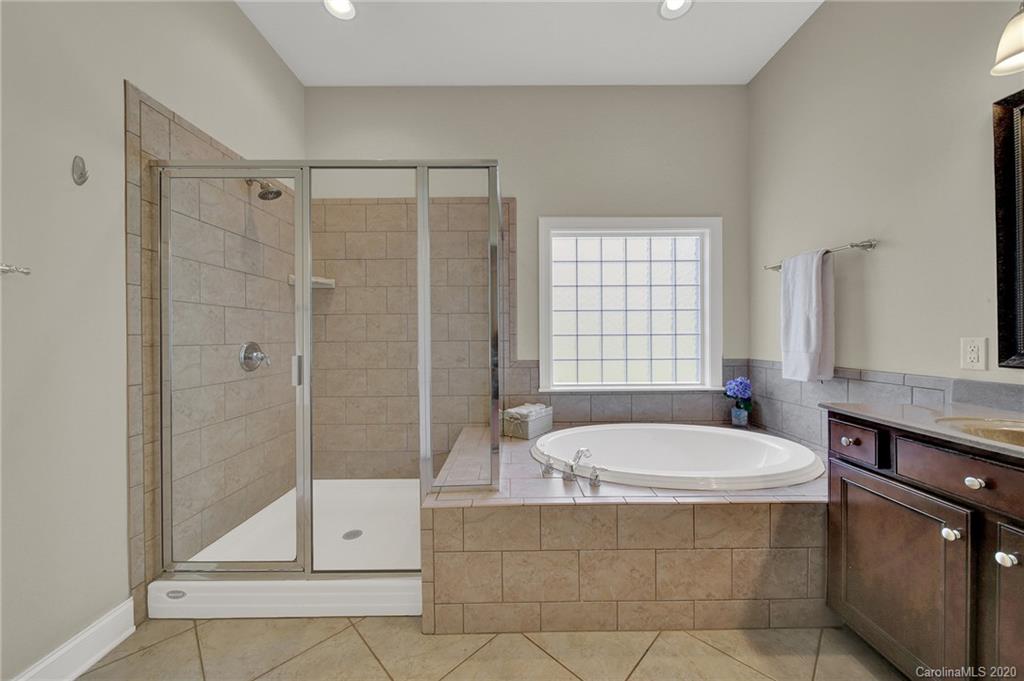 746 Quicksilver Trail Fort Mill, SC 29708 - Photo 16 of 35 a bathroom with a tub a sink a mirror and a shower