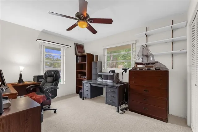 a view of a workspace with furniture and a window