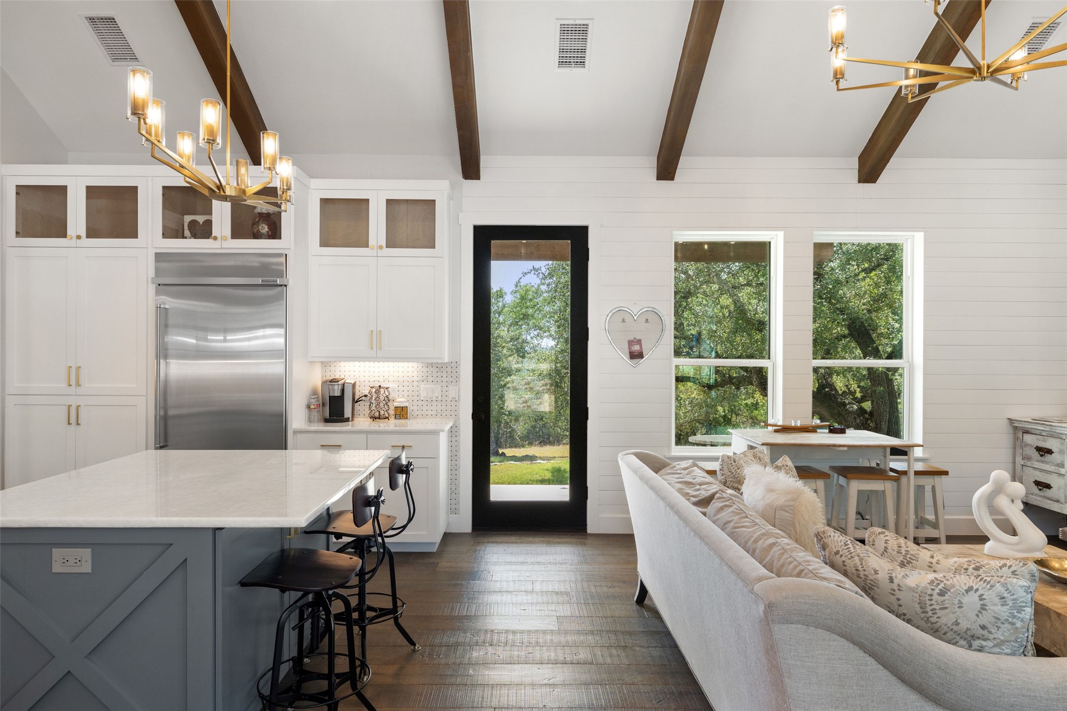 810 Kothmann Road Dripping Springs, TX 78620 - Photo 11 of 40 Exposed wood beams and rich hardwood flooring ground this airy, open-concept living space.