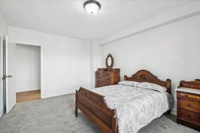 a bed sitting in a room next to a lamp