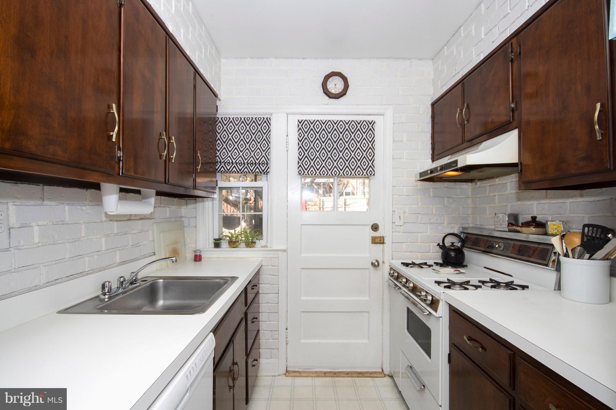 1809 Glen Ridge Road Towson, MD 21286 - Photo 9 of 30 a kitchen with a sink a stove a microwave cabinets and a window
