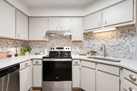 a kitchen with stainless steel appliances a stove a sink and cabinets