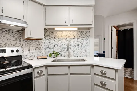 a kitchen with a sink and a stove top oven