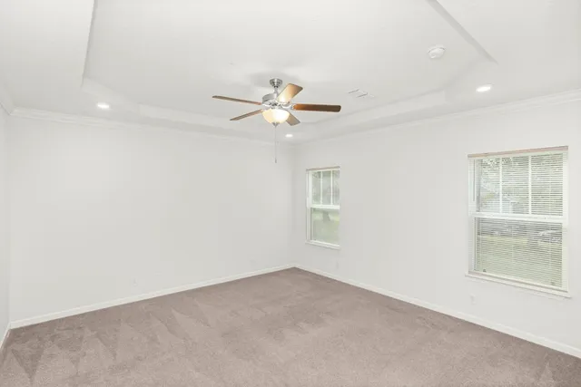 an empty room with a window and a ceiling fan