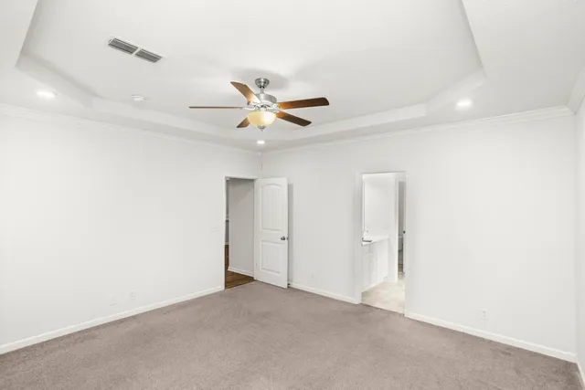 an empty room with ceiling fan and window