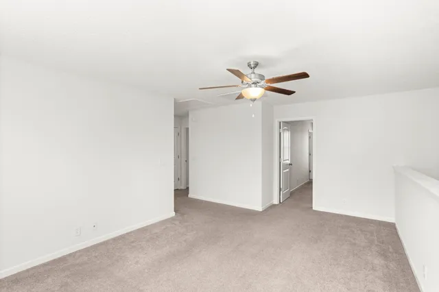 an empty room with a ceiling fan and a window