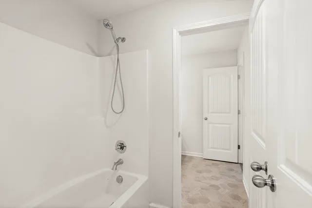 a bathroom with a bath tub with shower