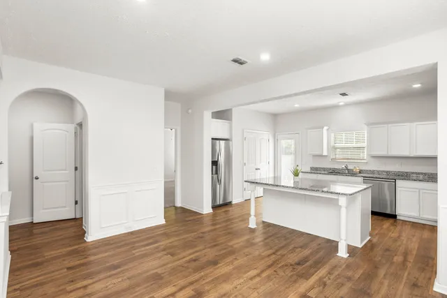 a kitchen with stainless steel appliances granite countertop a sink stove and wooden floor