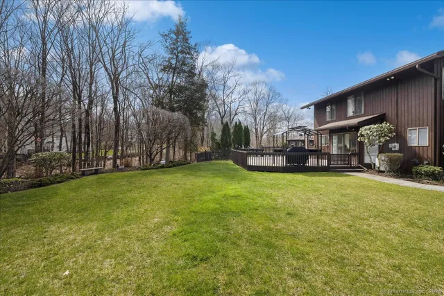 a view of a house with a big yard and large trees