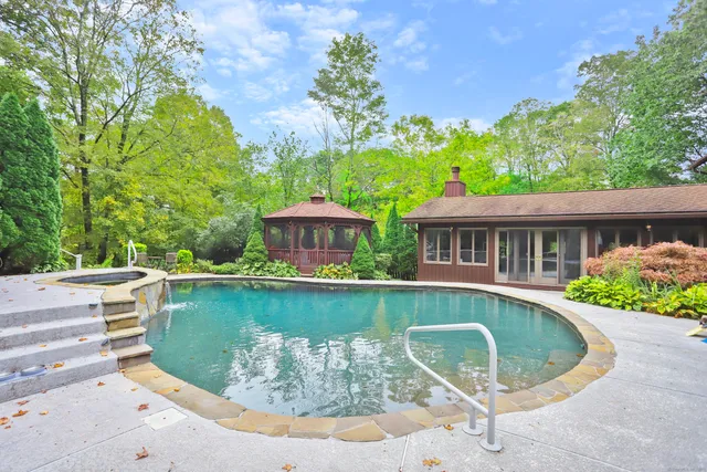 a view of a house with pool and chairs