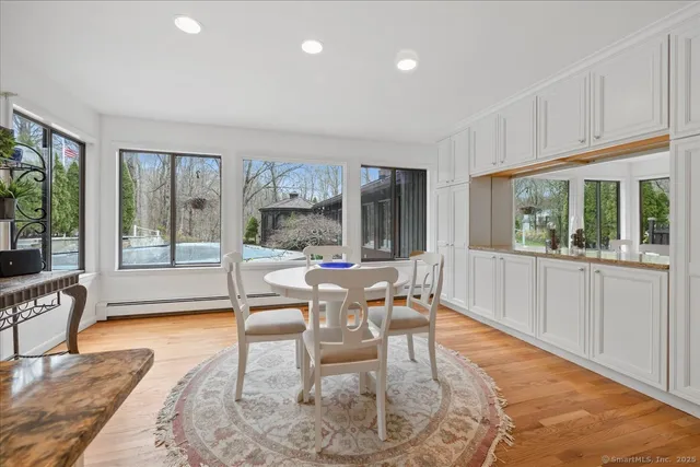 a dining room with wooden floor a glass table and chairs