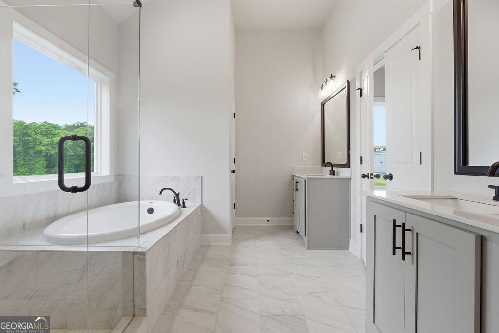 720 Youth Jersey Road Loganville, GA 30052 - Photo 20 of 31 a spacious bathroom with a tub sink and mirror