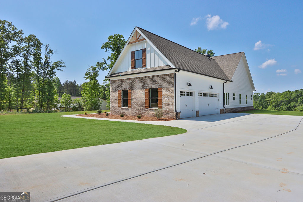 720 Youth Jersey Road Loganville, GA 30052 - Photo 3 of 31 a front view of a house with a yard and garage