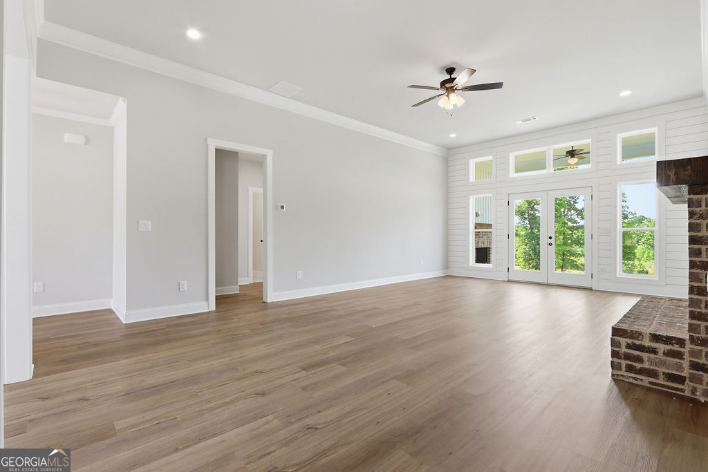 720 Youth Jersey Road Loganville, GA 30052 - Photo 5 of 31 a view of an empty room with a window and wooden floor