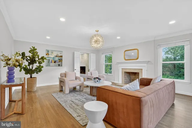 a living room with furniture a fireplace and a large window