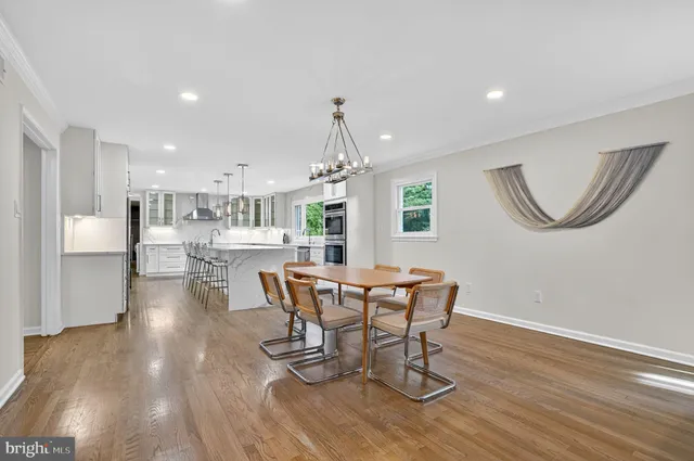 a large kitchen with kitchen island a sink table and chairs