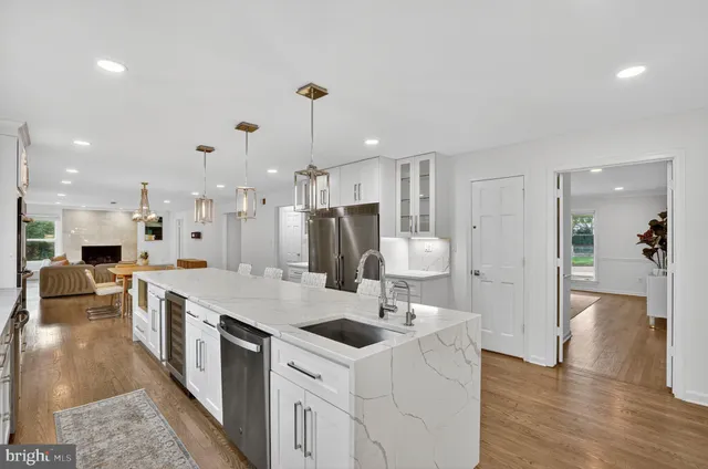 a kitchen with stainless steel appliances granite countertop a sink a oven a dining table and chairs