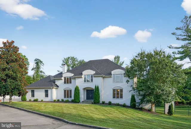 a front view of a house with a yard and trees
