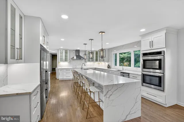 a kitchen with stainless steel appliances granite countertop a sink a stove and a refrigerator