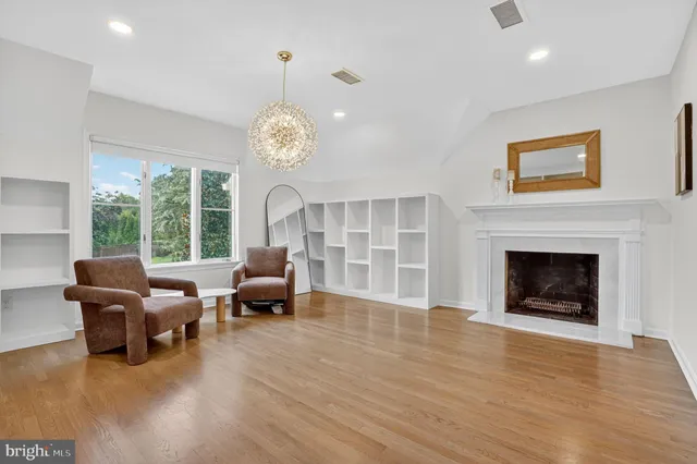 a bedroom with a bed mirror and dresser