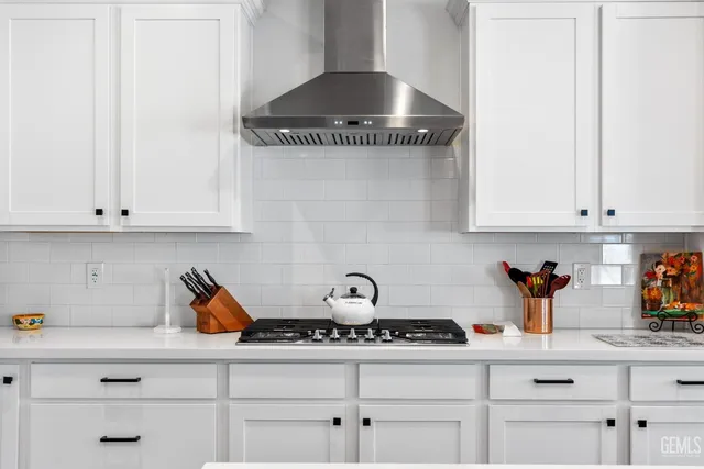 a kitchen with white cabinets and a stove