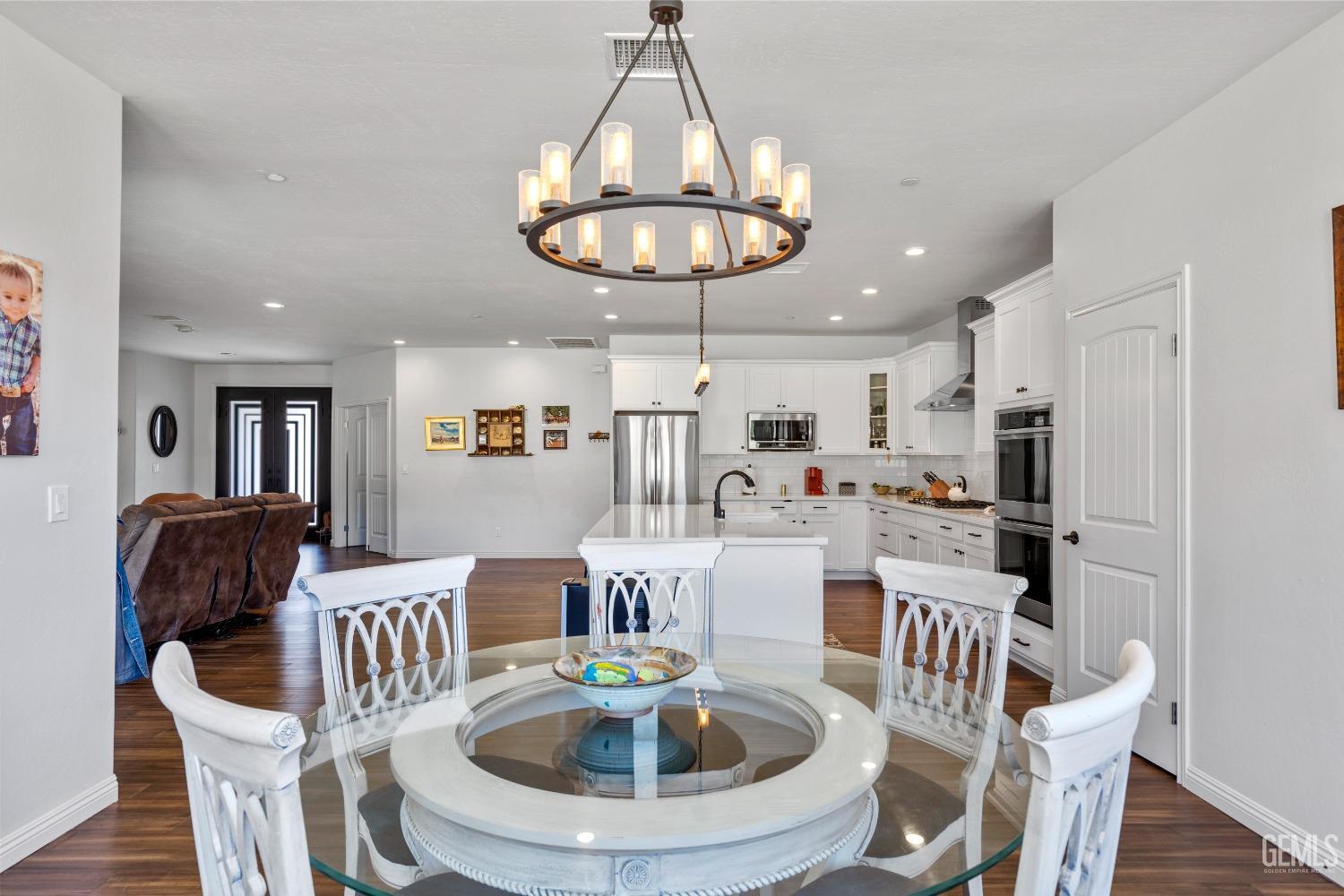Undisclosed Address Tehachapi, CA 93561 - Photo 14 of 41 a kitchen with stainless steel appliances a dining table and chairs