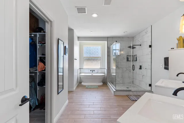 a bathroom with a tub shower and mirror